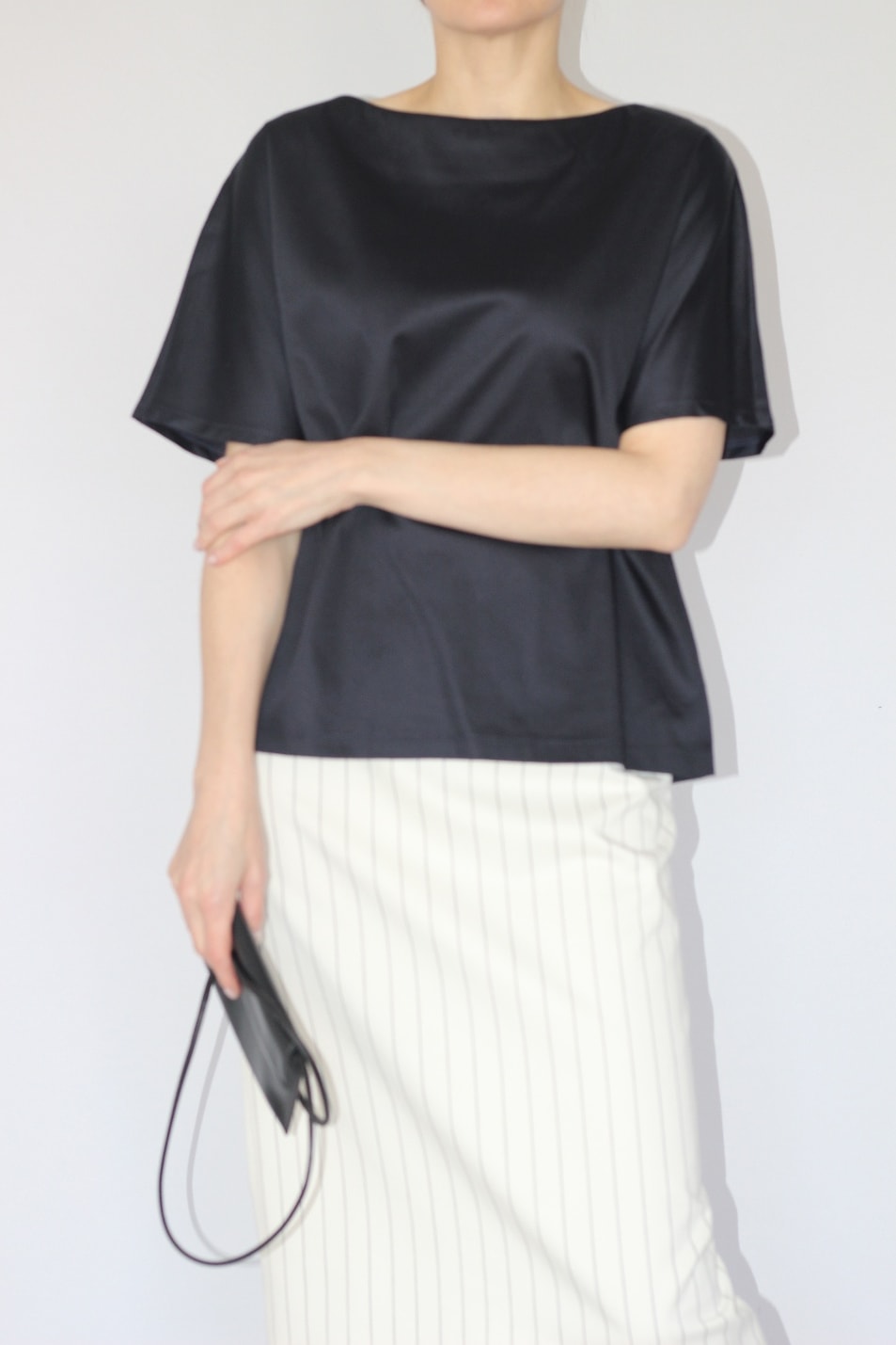 A LÉKAMKA look: black short-sleeved top with a white pinstripe skirt